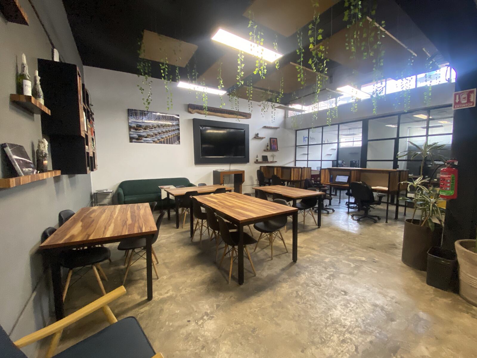 Coworking con escritorios y muro de libreros