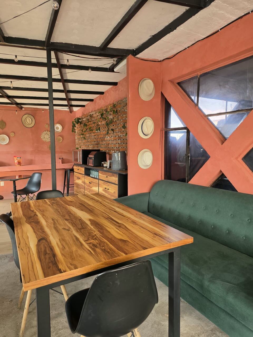 Sala de descanso con sillón verde y muro terracota